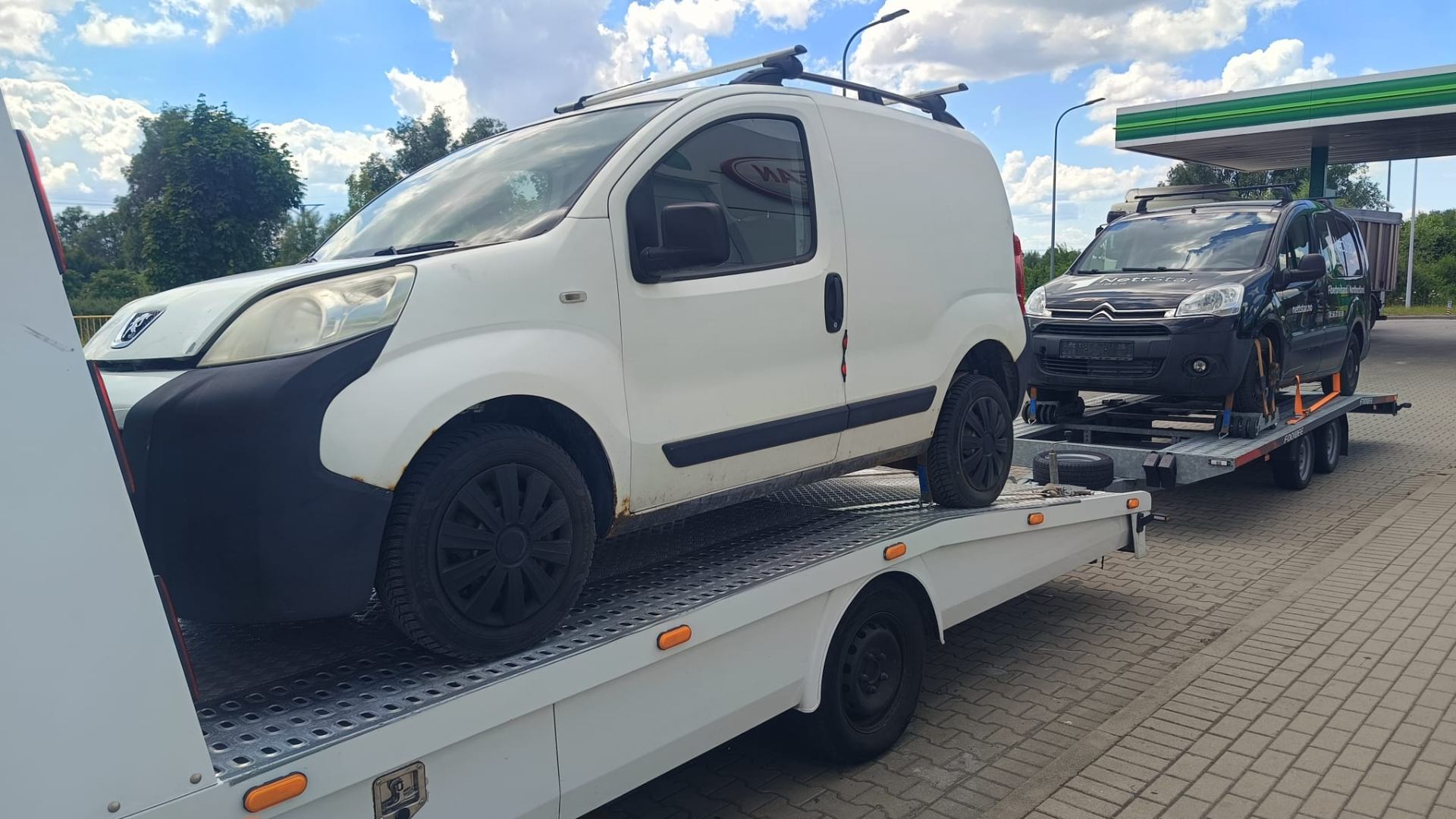 Transport dwóch samochodów dostawczych lawetą z przyczepą
